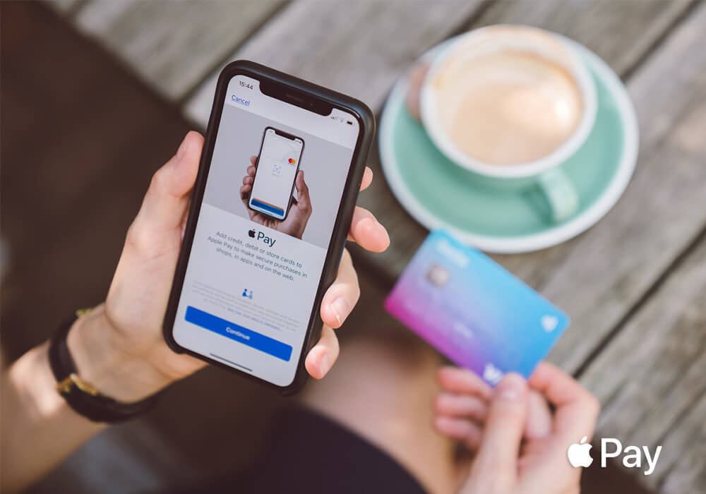 Person paying tab using Apple Pay from their phone